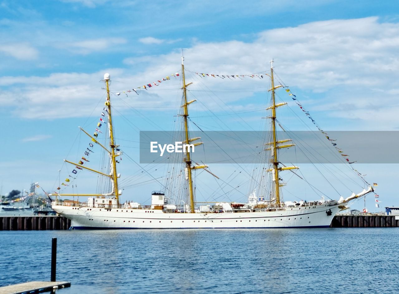 nautical vessel, transportation, water, vehicle, mode of transportation, sea, ship, tall ship, sailboat, sailing ship, sky, sailing, cloud, pole, nature, harbor, architecture, mast, boat, watercraft, pier, no people, day, windjammer, travel, outdoors, blue, schooner, commercial dock, passenger ship, frigate, galleon