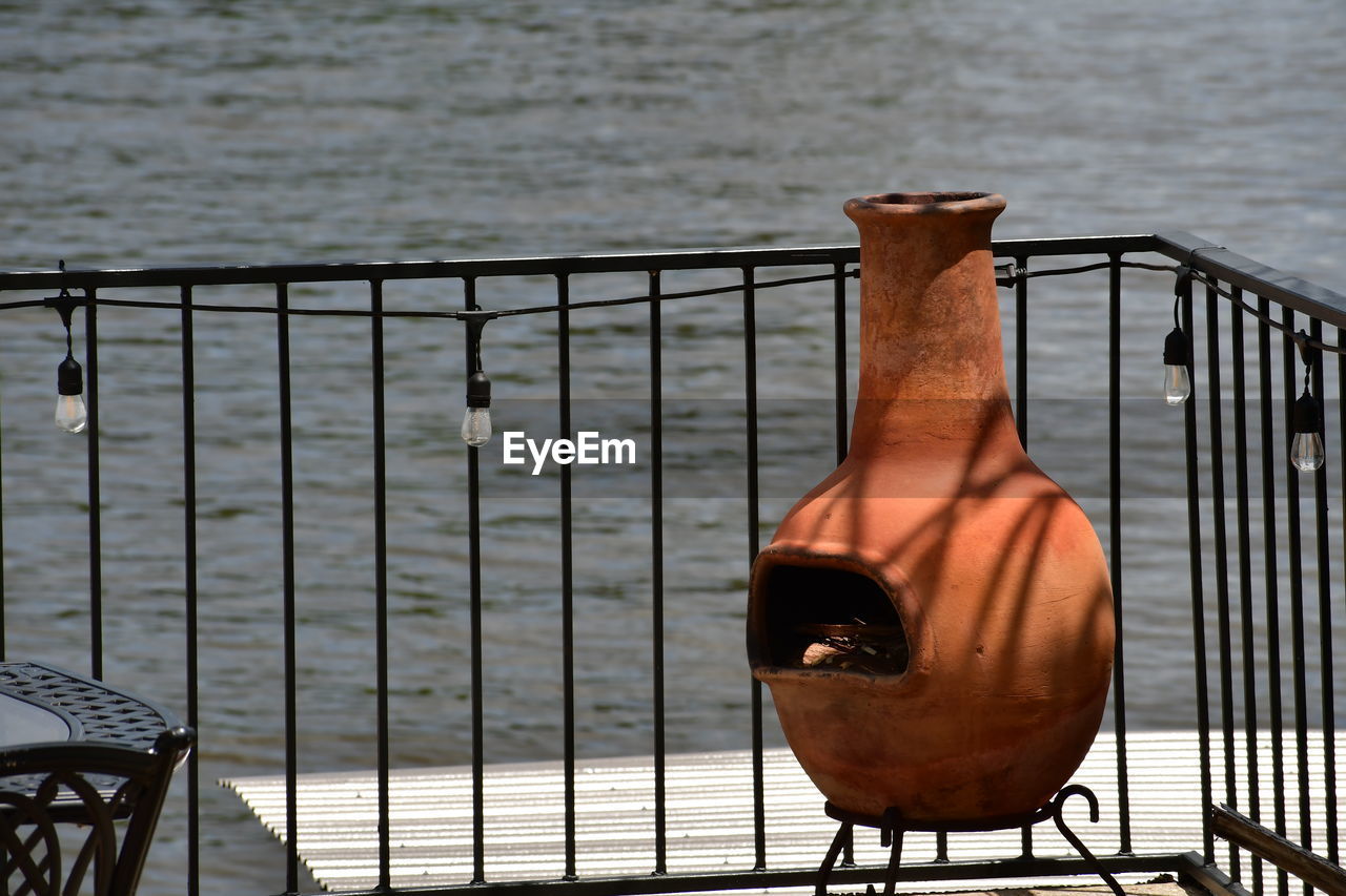 Close-up of metal railing against sea