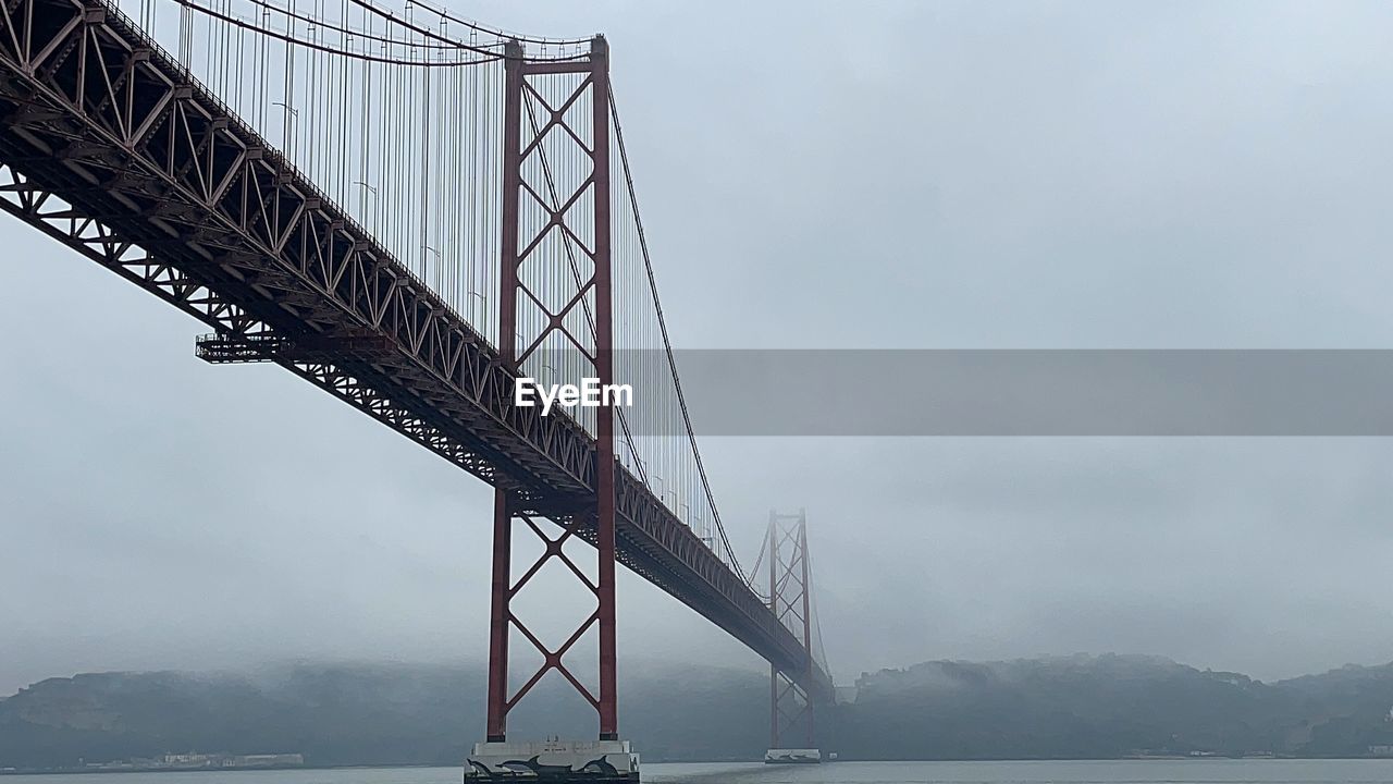 Low angle view of suspension bridge against sky