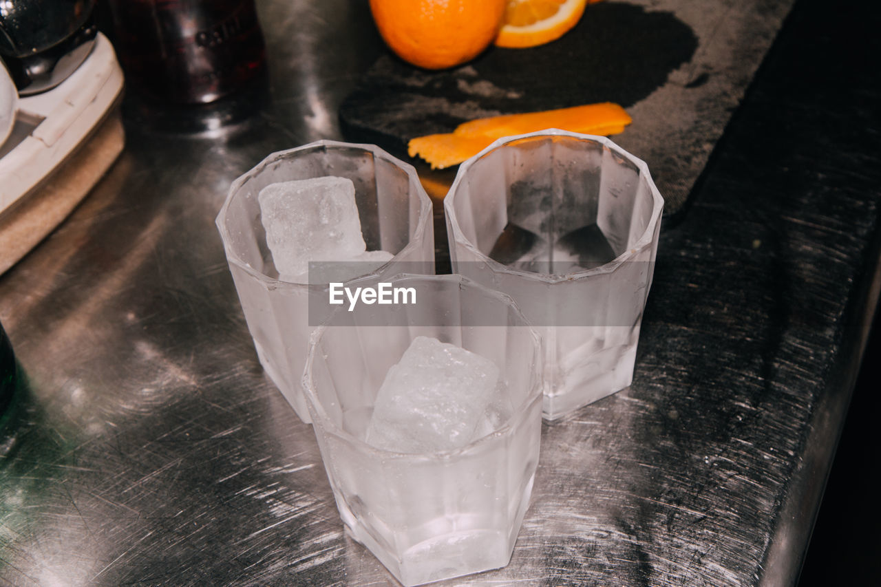 Close-up of ice cubes in drinking glasses on table