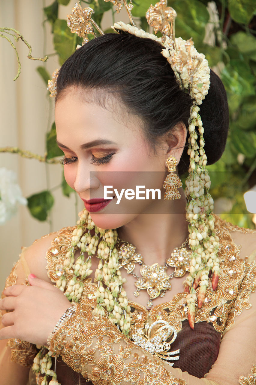 Close-up of woman wearing traditional clothing against plants