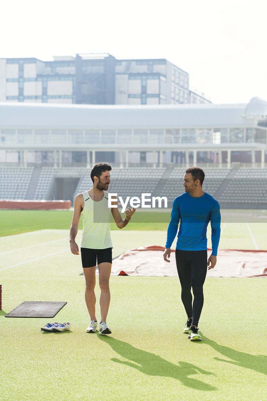 Male athletes walking at sports field