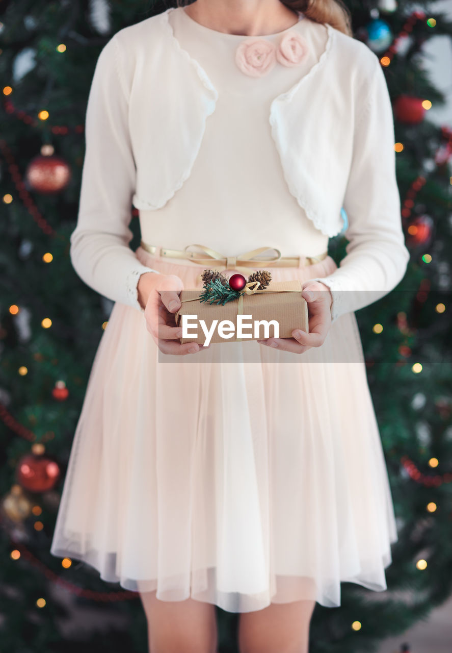 Midsection of a girl holding christmas present