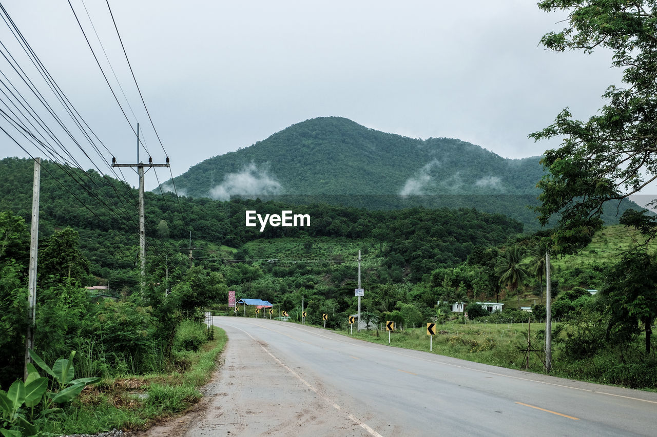 Road by mountains against sky