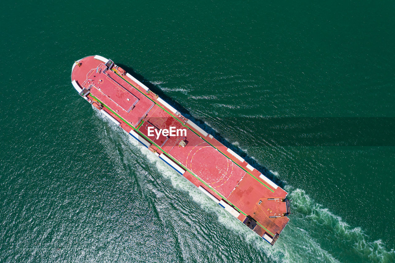 Aerial view of the huge ro-ro ship loading new cars. automotive container carriers sailing 