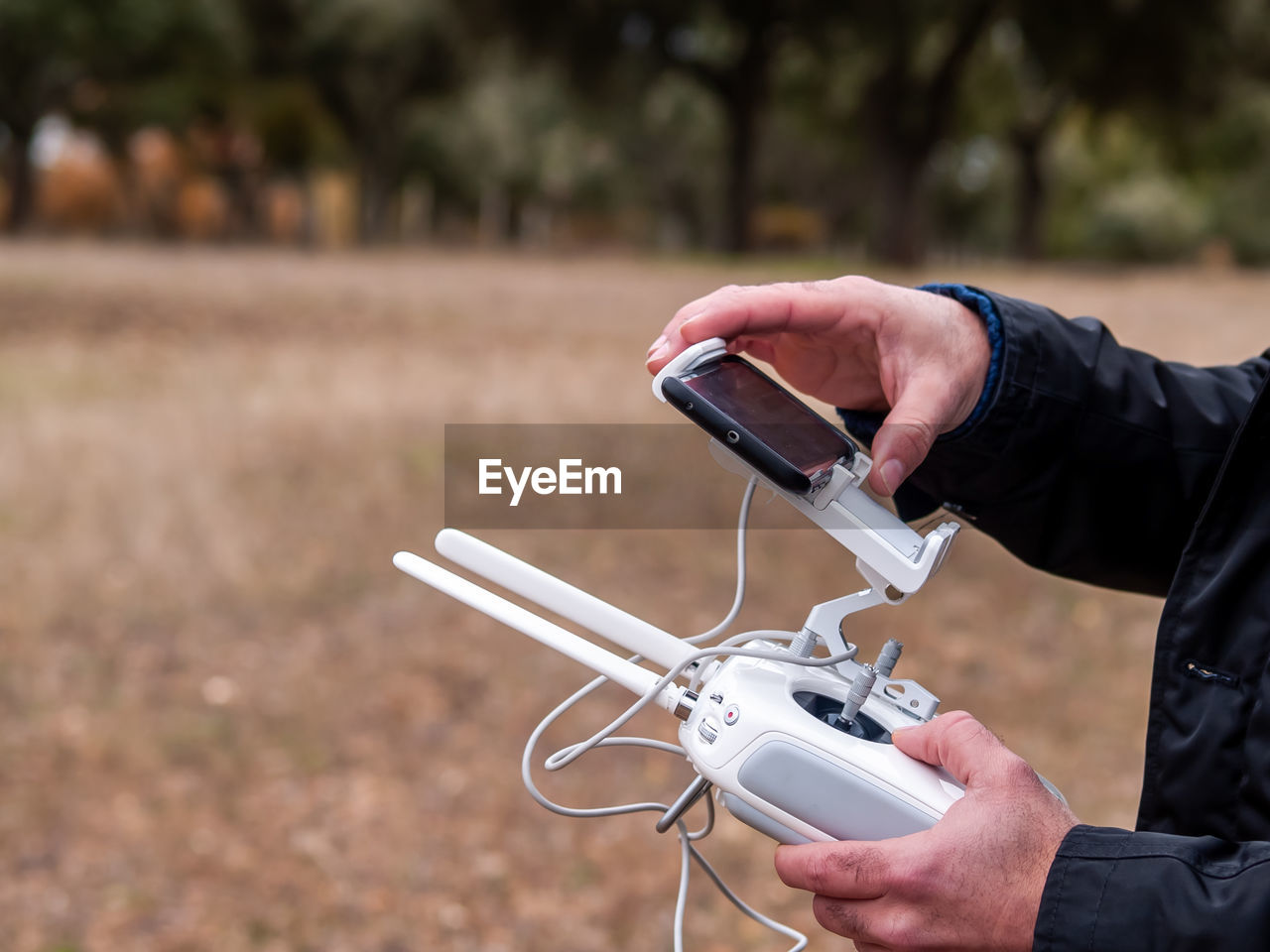 Midsection of man using drone remote control on land