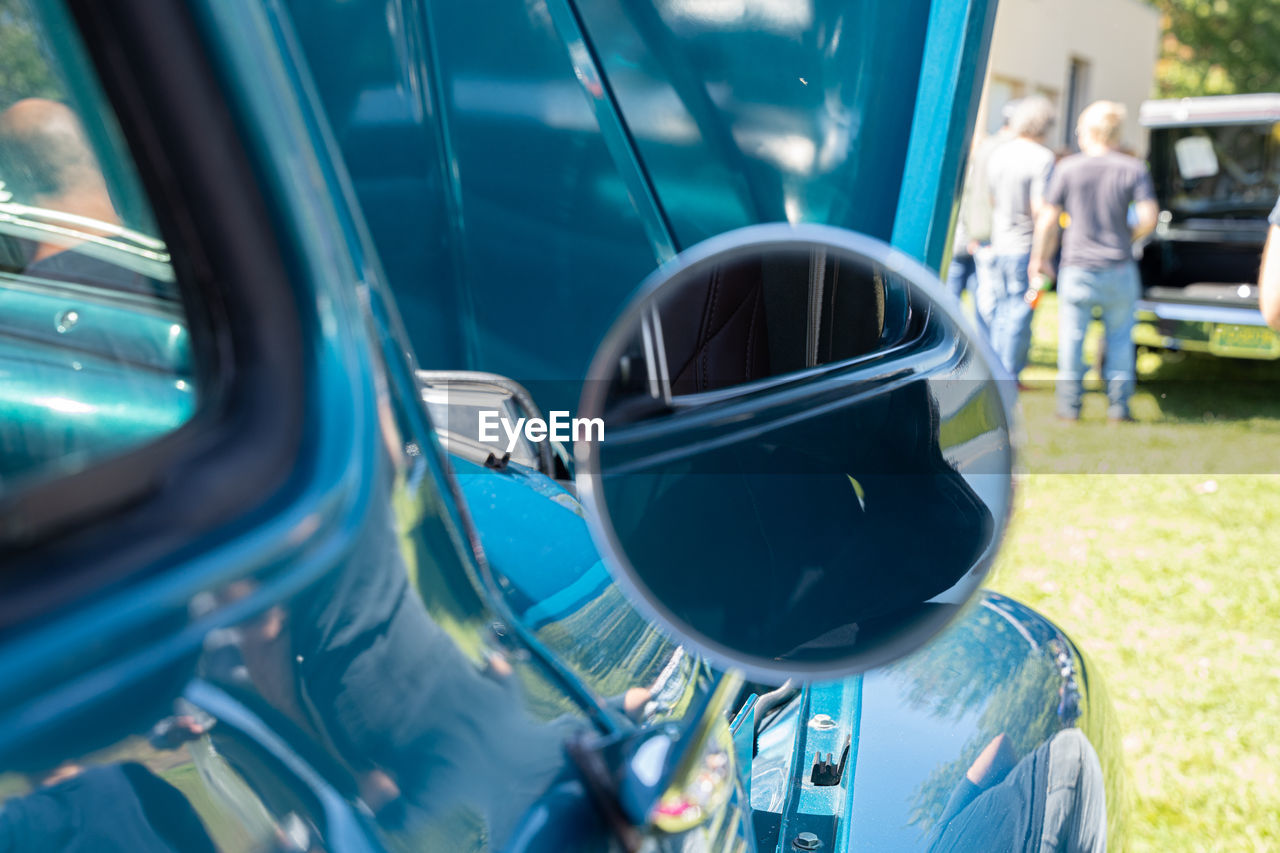 CLOSE-UP OF SIDE-VIEW MIRROR AGAINST CAR