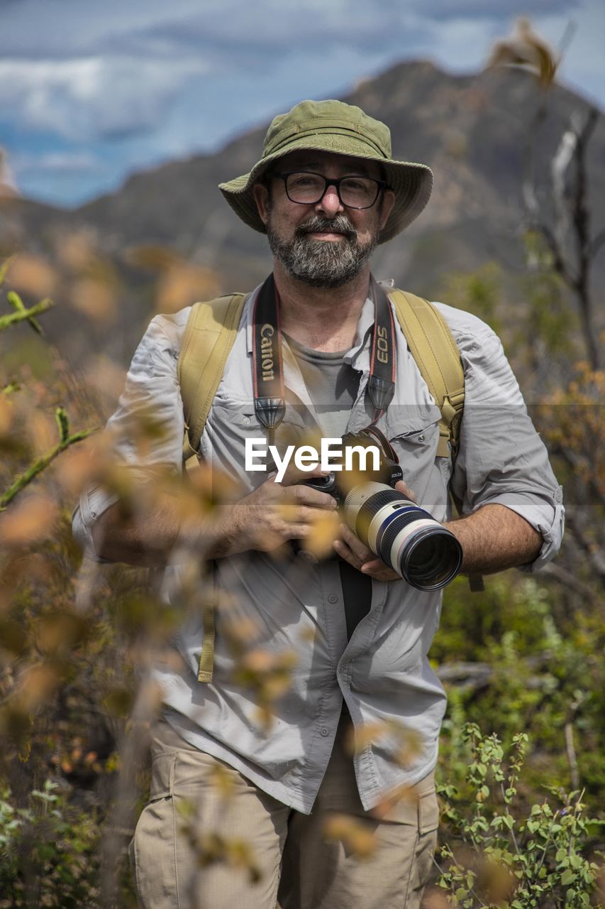 MAN WEARING HAT STANDING ON LAND