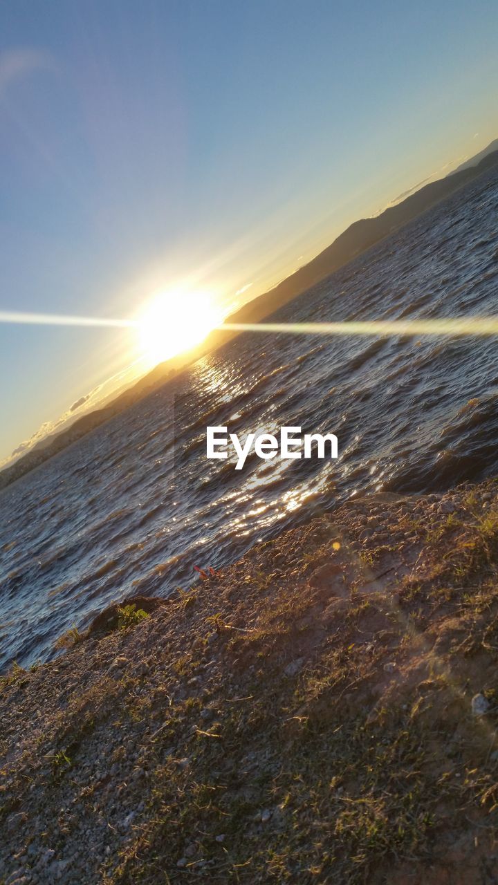 VIEW OF CALM BEACH AGAINST SKY DURING SUNSET