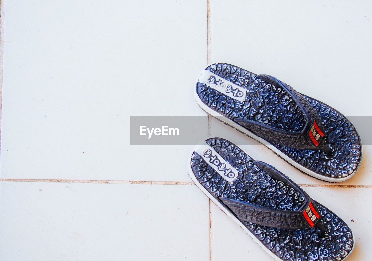 CLOSE-UP OF SHOES ON TILED FLOOR