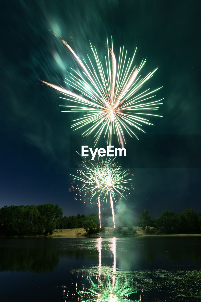 FIREWORK DISPLAY OVER LAKE AGAINST SKY