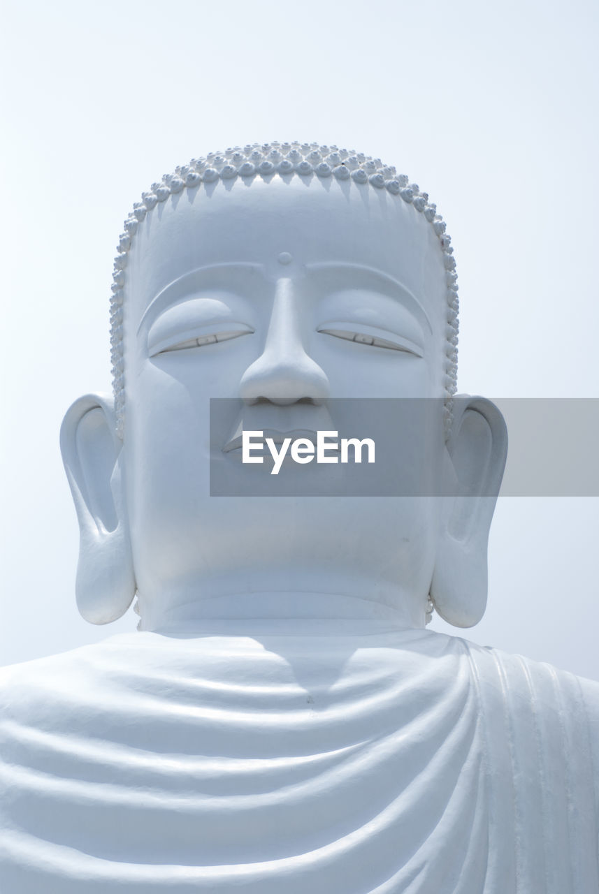 Close-up of buddha statue against clear sky