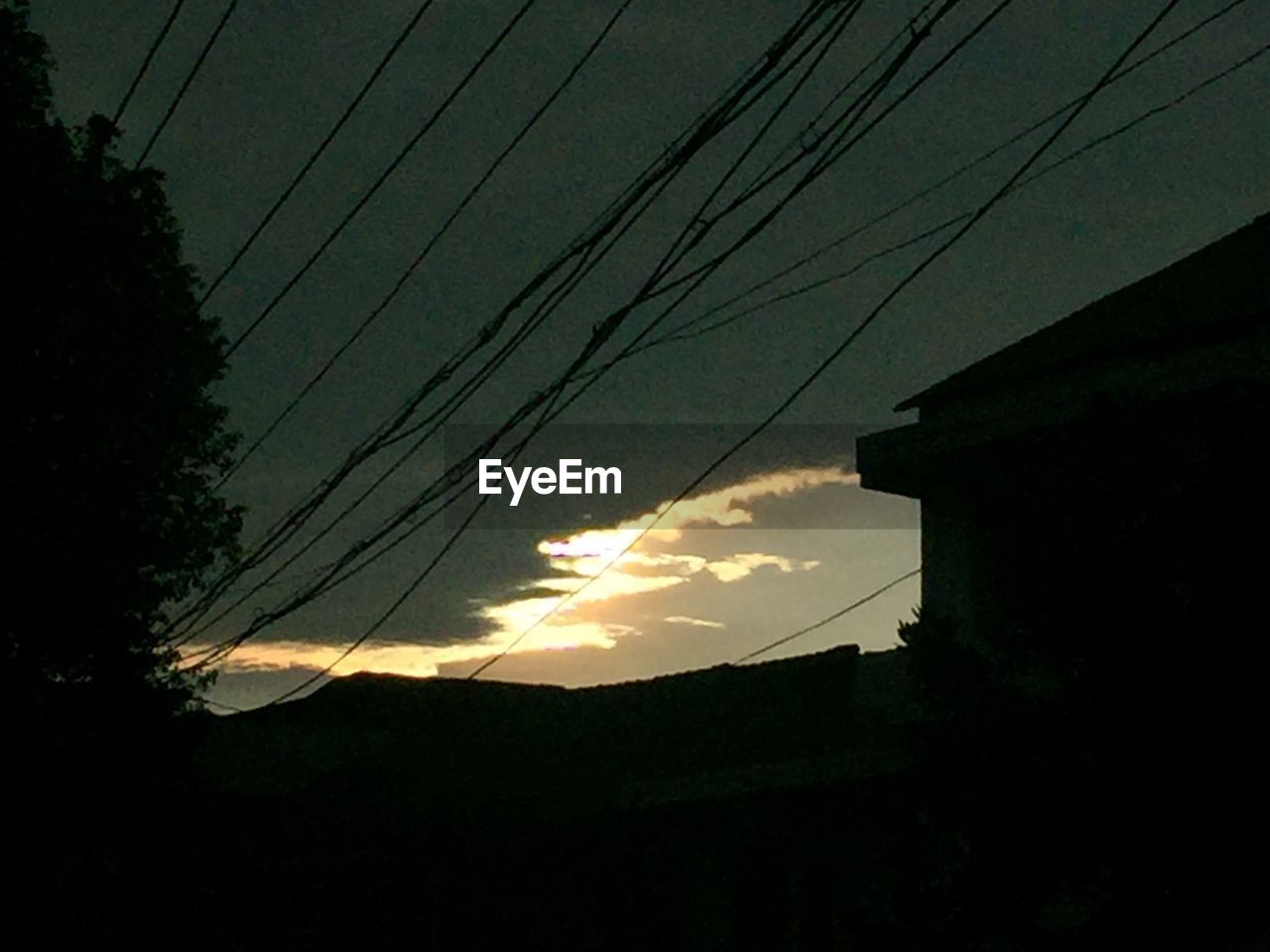 LOW ANGLE VIEW OF POWER LINES AGAINST SKY AT SUNSET