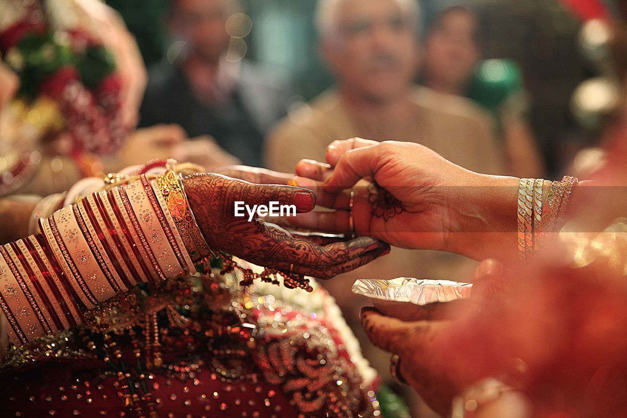 Cropped hand of mother with bride during wedding ceremony