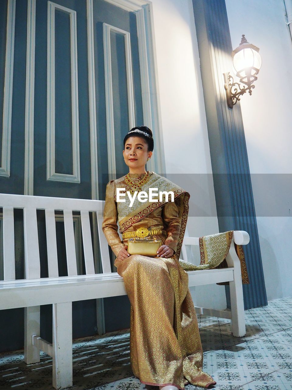 Woman wearing sari sitting on bench