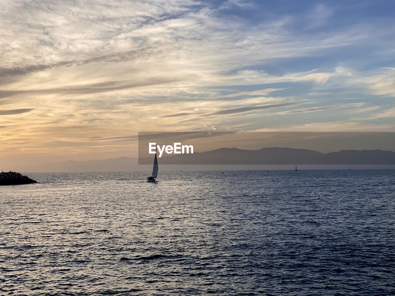 SAILBOATS SAILING IN SEA AGAINST SKY DURING SUNSET