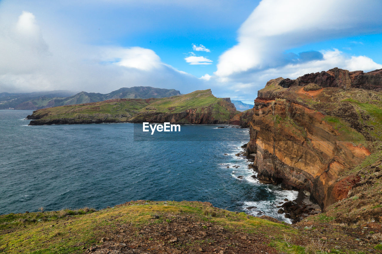 Scenic view of sea and mountains against sky