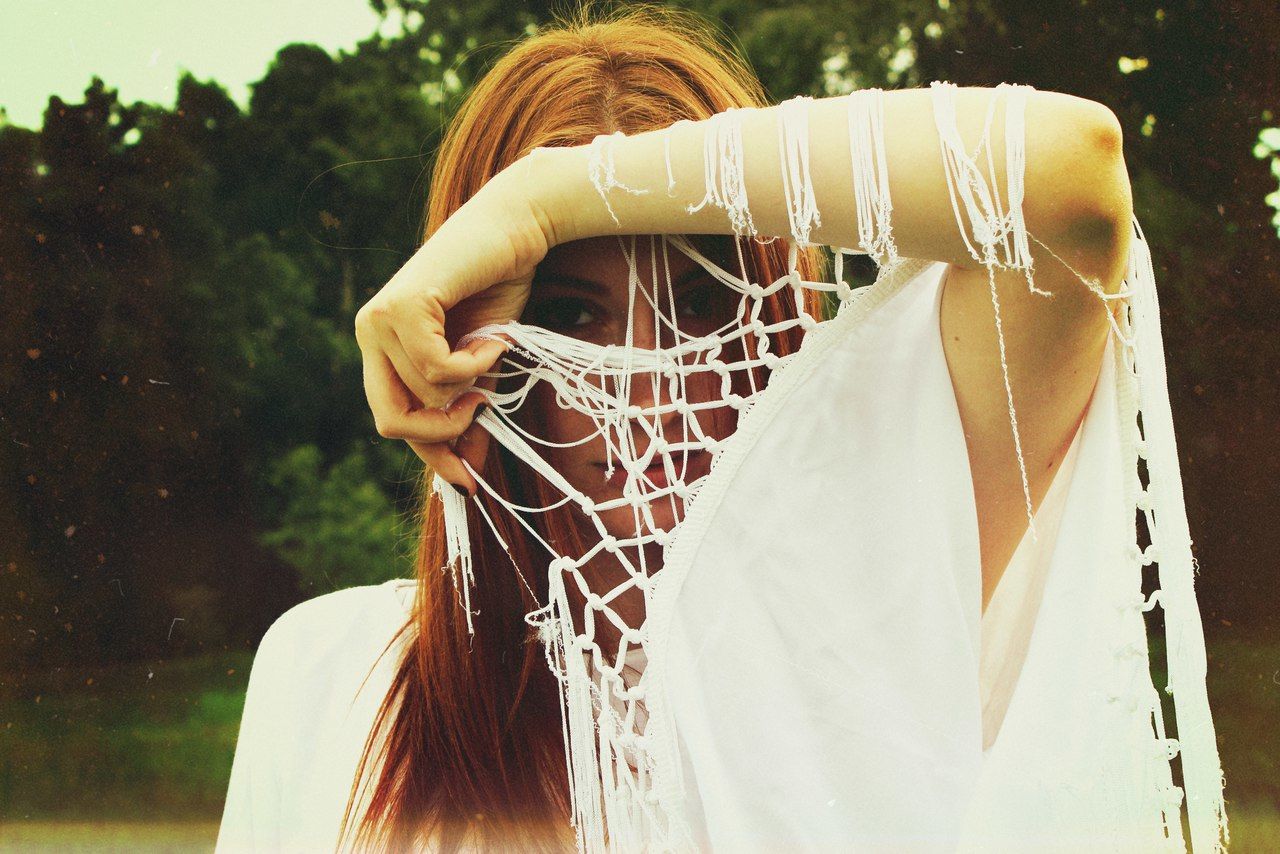 Woman looking through tassels while standing at park