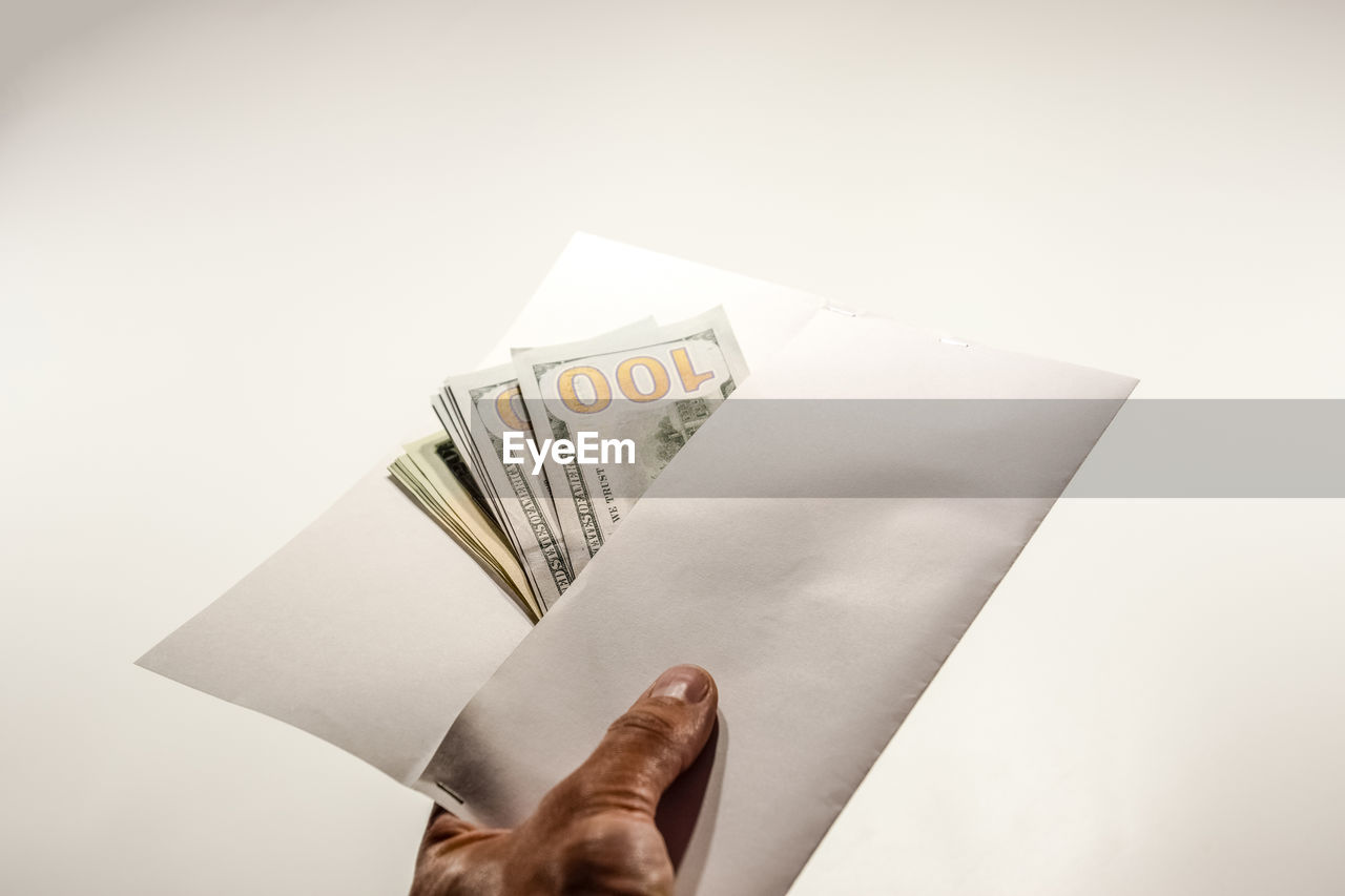 finance, currency, paper currency, business, wealth, one person, hand, paper, cash, holding, studio shot, copy space, adult, finance and economy, indoors, success, business finance and industry, paying, savings