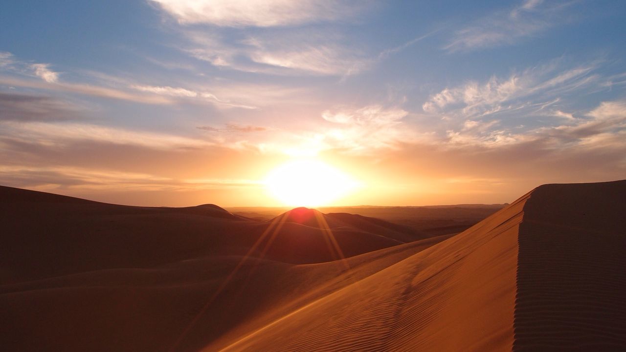 Scenic view of desert against sky at sunset