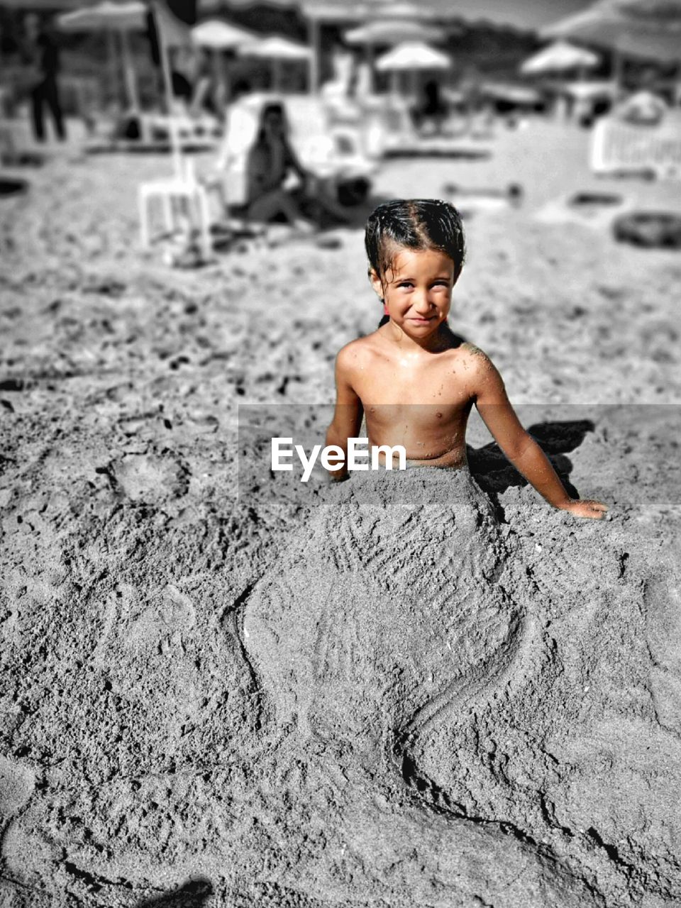 PORTRAIT OF SHIRTLESS BOY ON SAND IN MUD