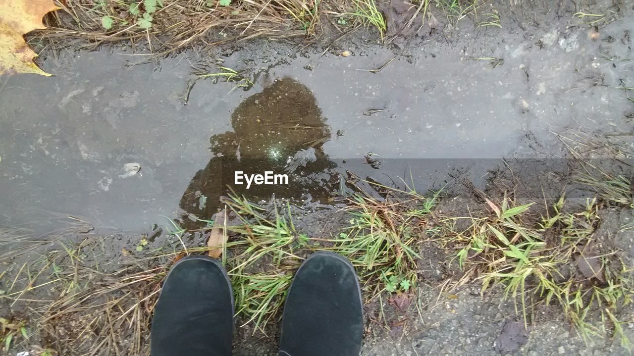 LOW SECTION OF WOMAN STANDING ON WATER