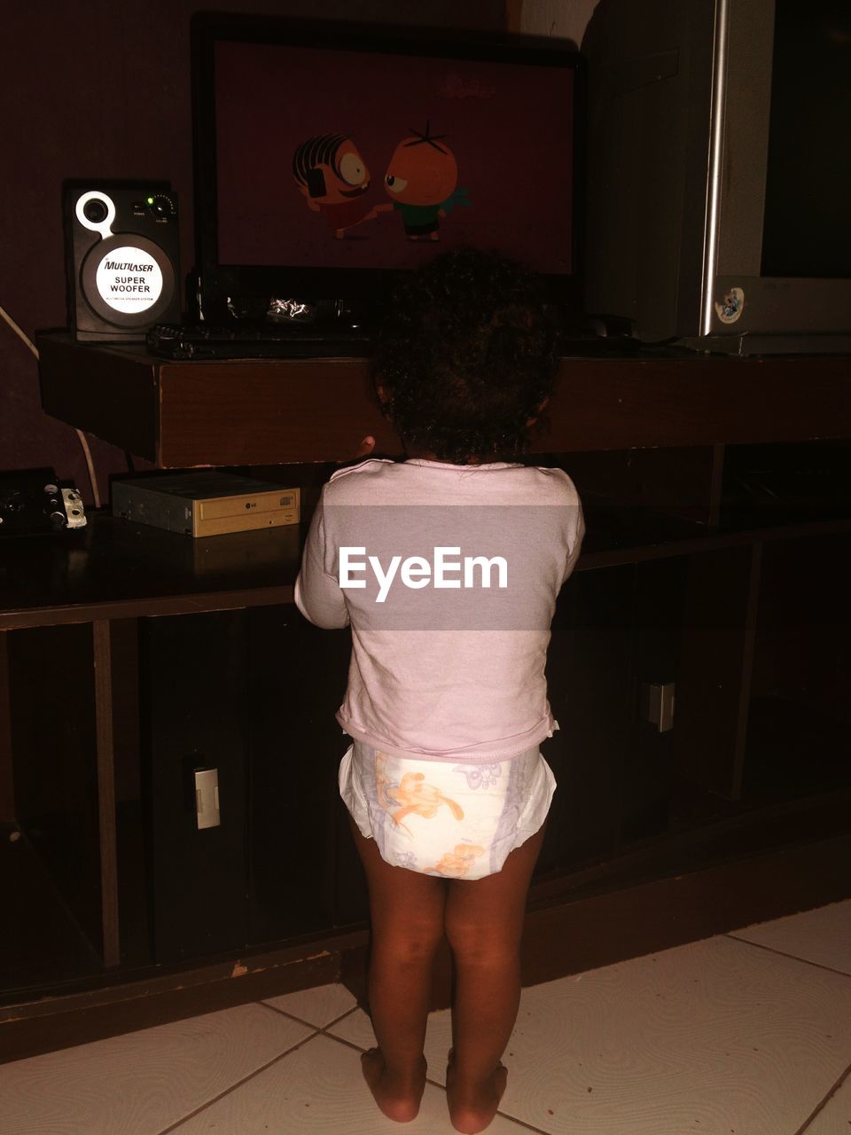 Rear view of baby girl standing at home