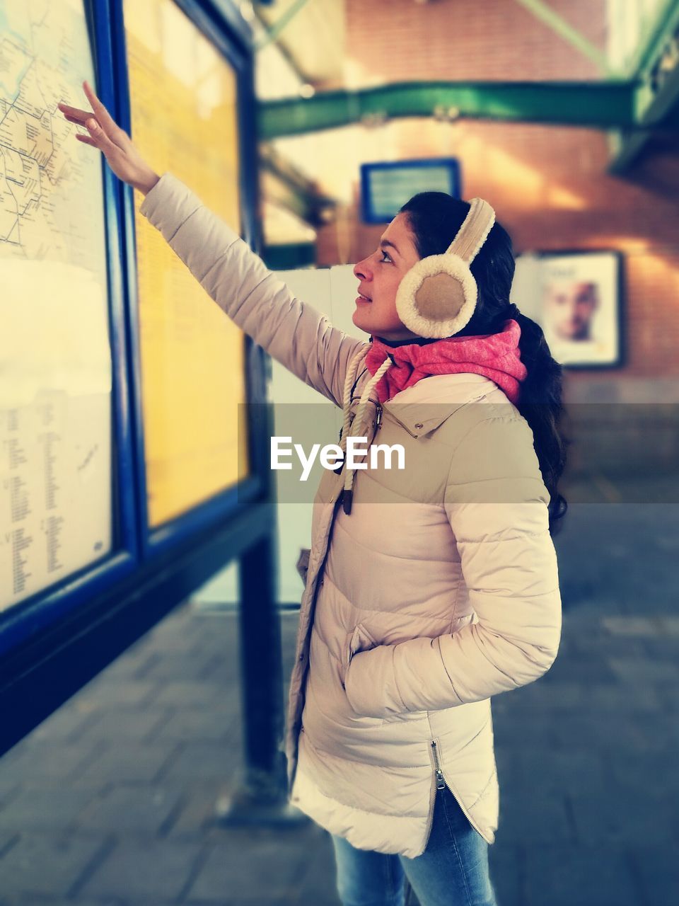 Side view of woman looking at map at station