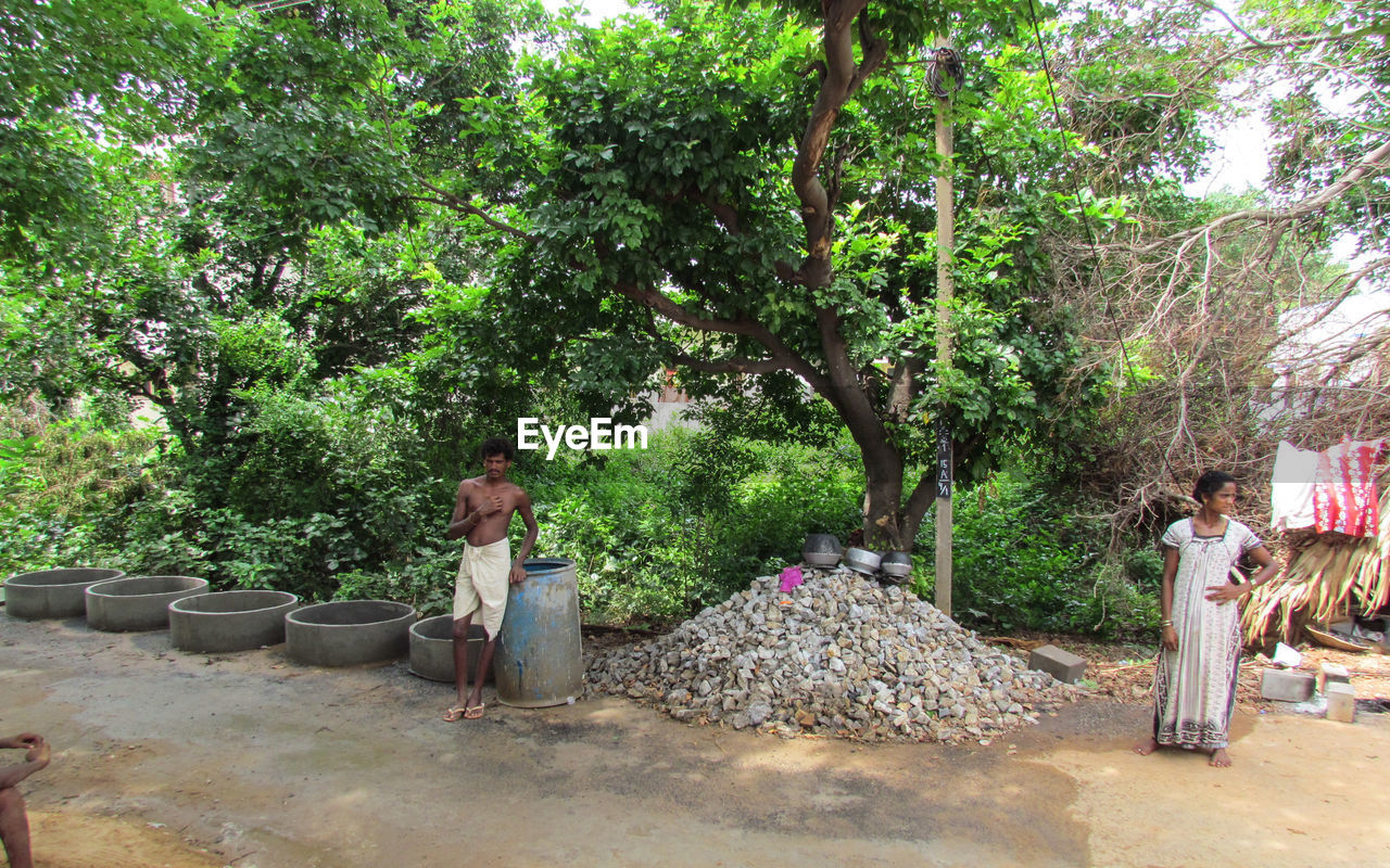 WOMAN STANDING BY TREE IN PARK