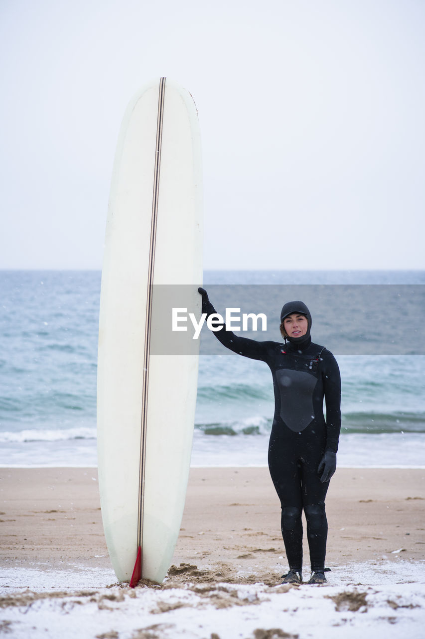 Young woman going winter surfing in snow