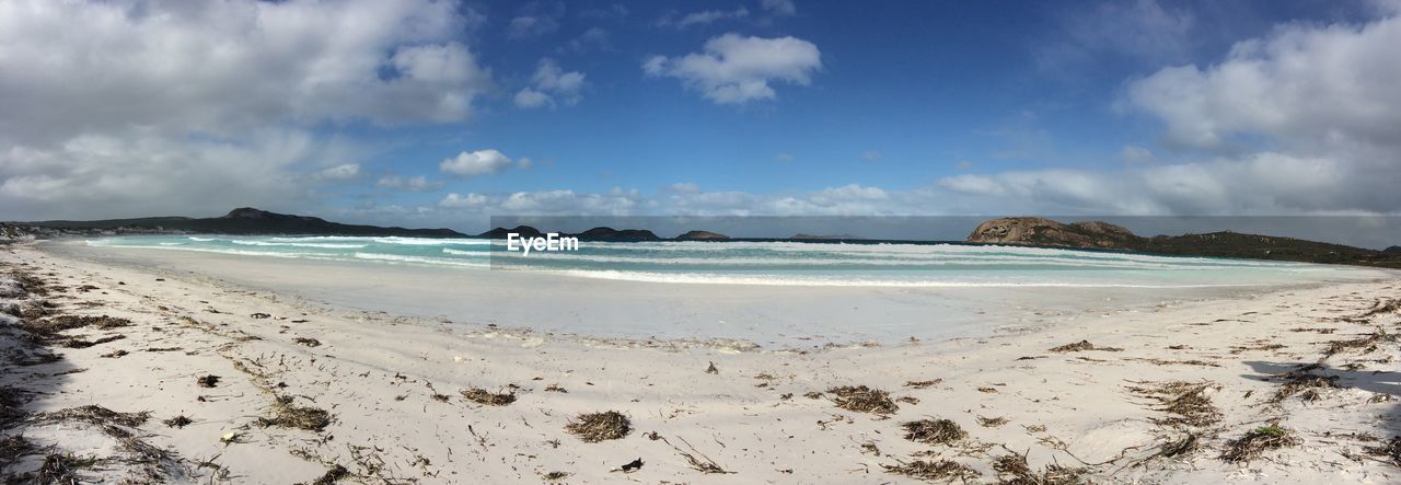 Scenic view of beach against cloudy sky