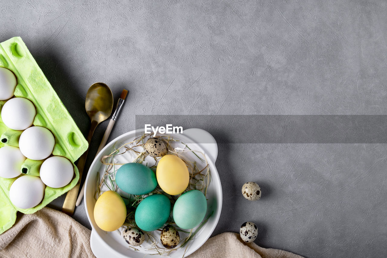 Easter composition with chicken and quail eggs, cardboard container for eggs. copy space.