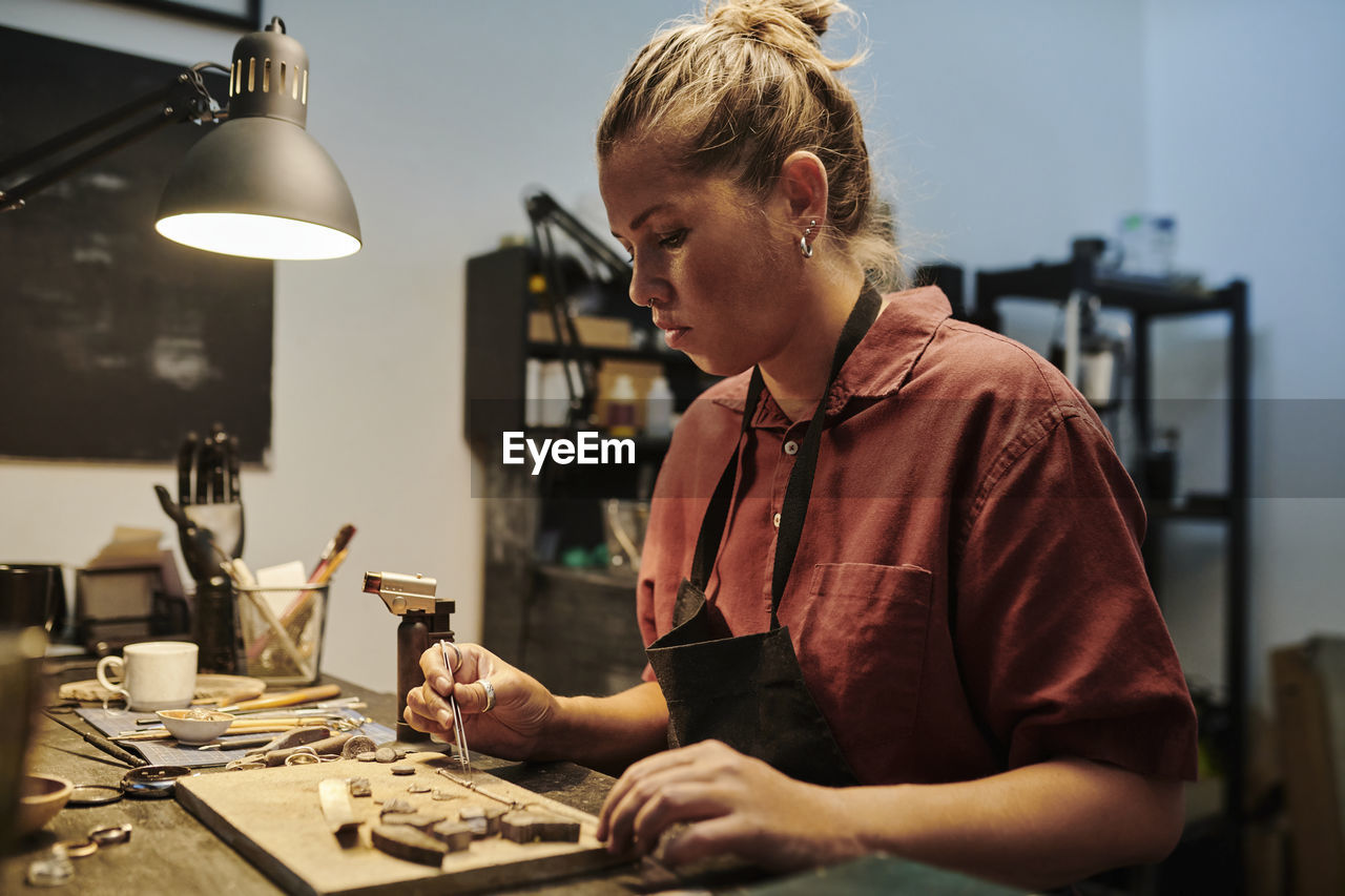 Jeweller working at workbench in workshop