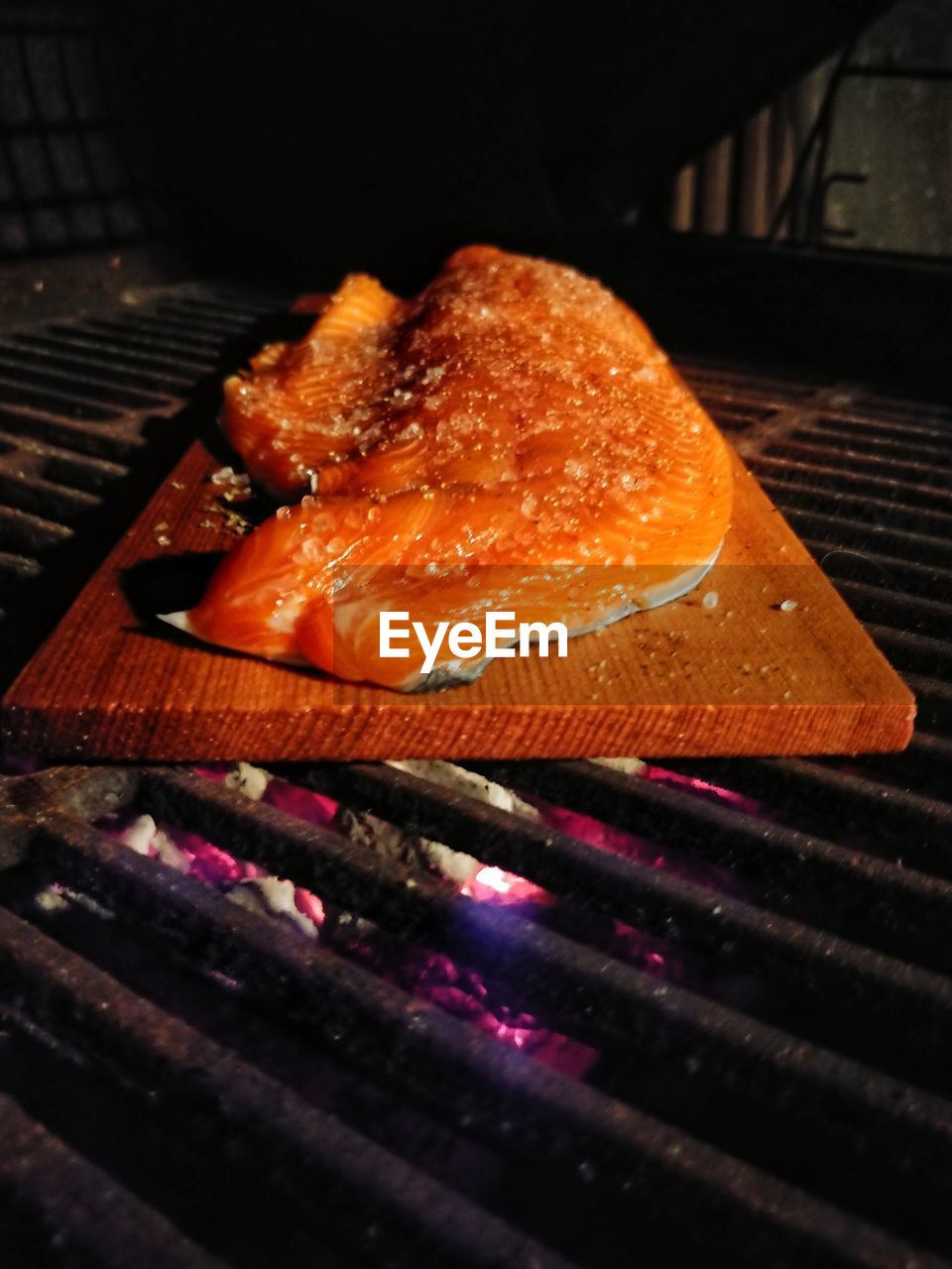 CLOSE-UP OF MEAT ON BARBECUE GRILL AT TABLE