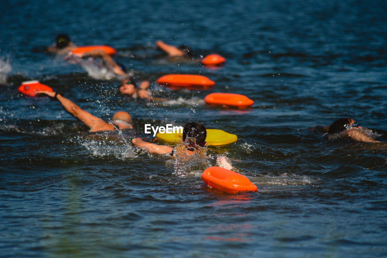 Rear view of people swimming in sea