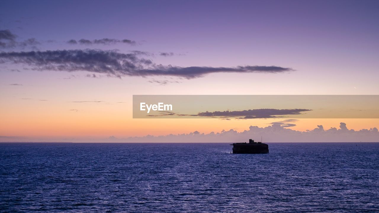 SILHOUETTE BOAT IN SEA AGAINST CLEAR SKY