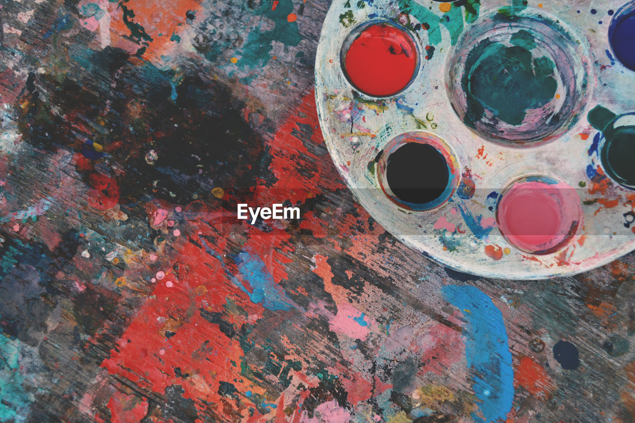High angle view of colorful palette on stained wooden table