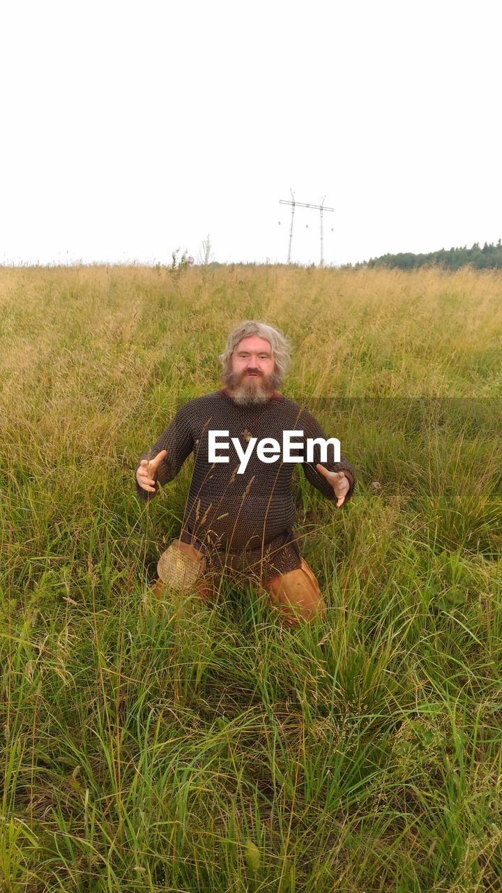 MAN SITTING ON FIELD