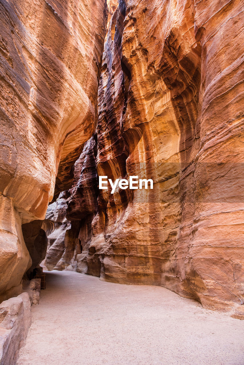 Low angle view of pathway amidst rock formations