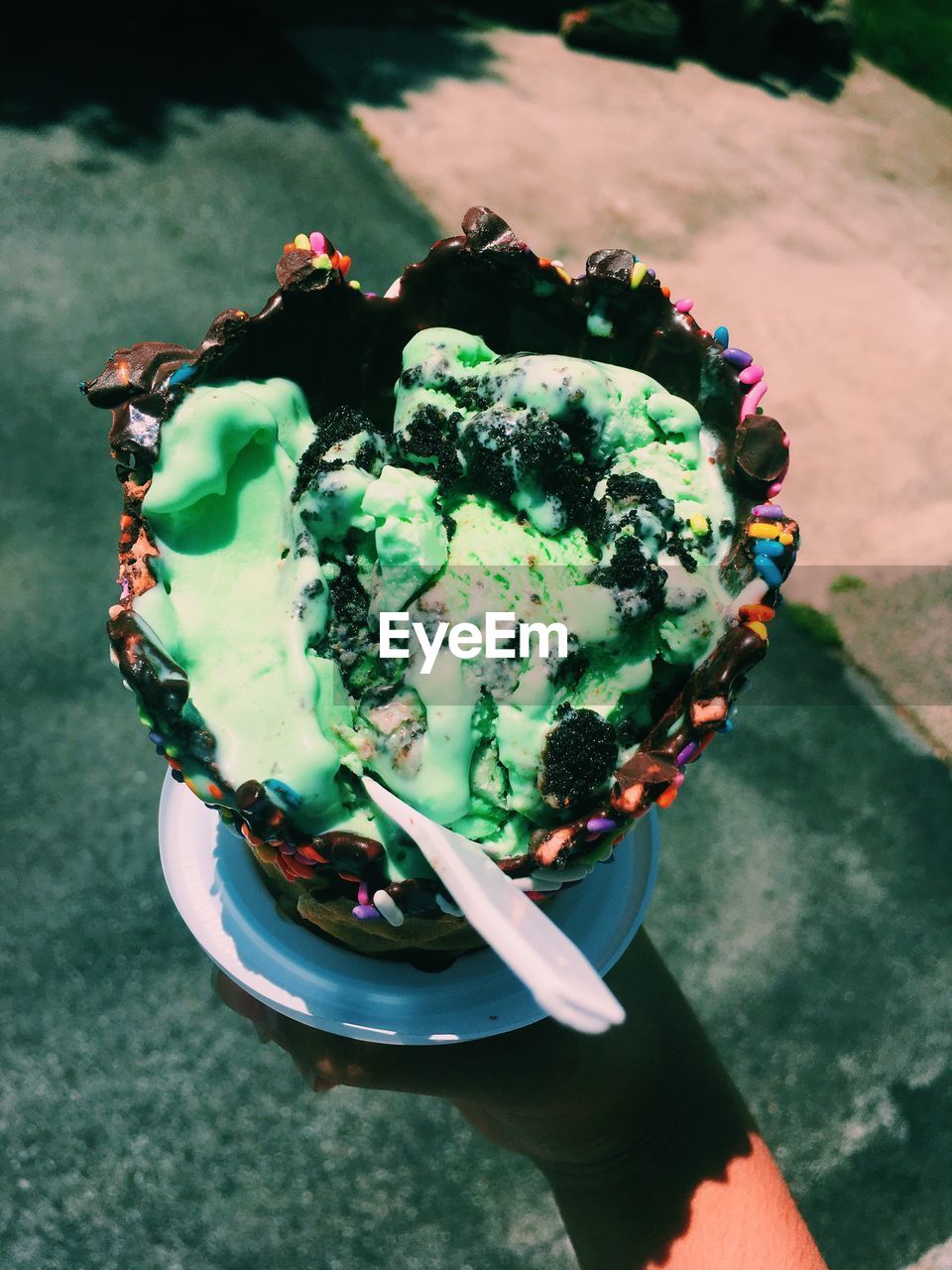 Cropped hand of person holding ice cream in bowl