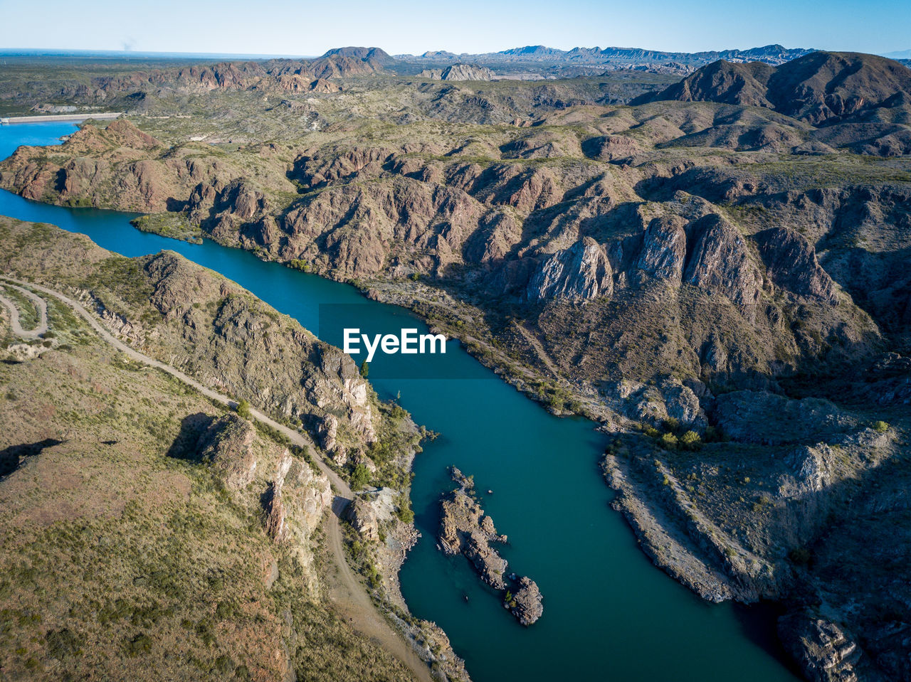 Scenic view of river by mountains against sky