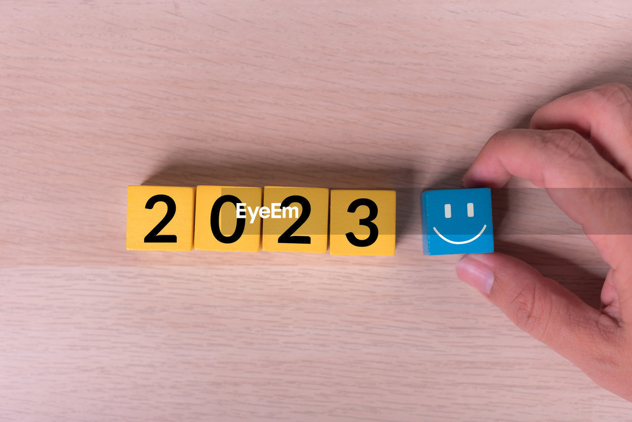 cropped hand of person holding toy blocks on table