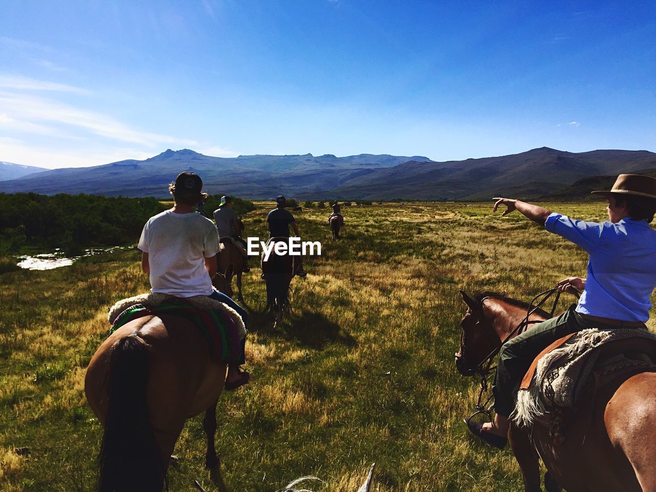 Rear view of horse riding on landscape