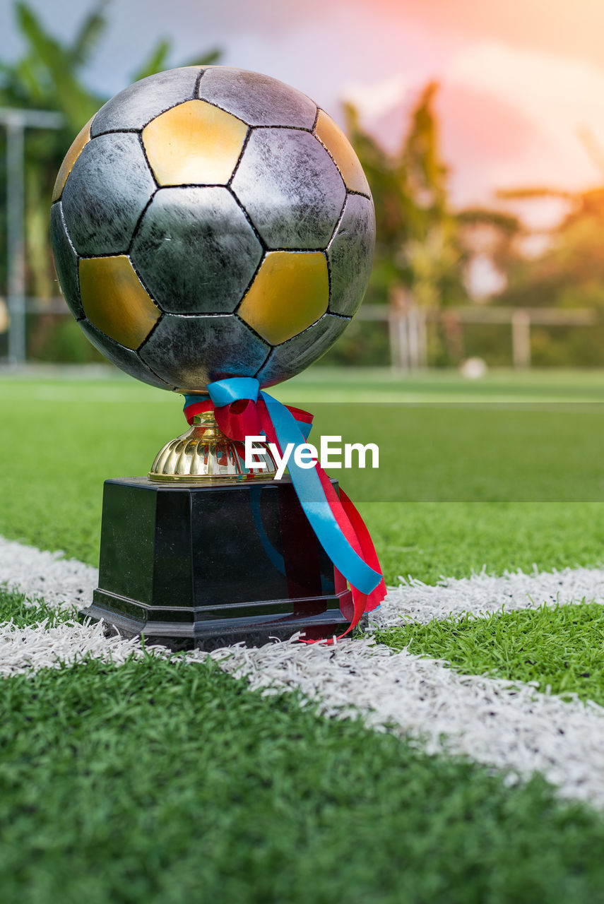 CLOSE-UP OF SOCCER BALL ON GRASS AT BEACH