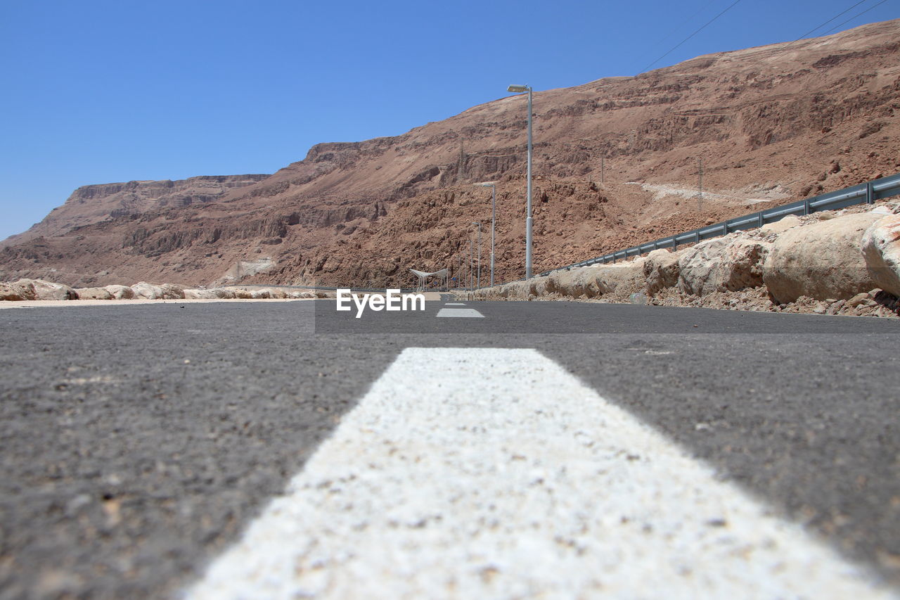 Road by mountain against clear sky