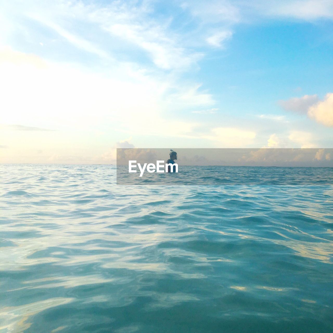 MAN IN SEA AGAINST SKY