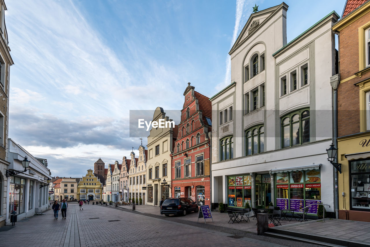 BUILDINGS BY STREET AGAINST SKY