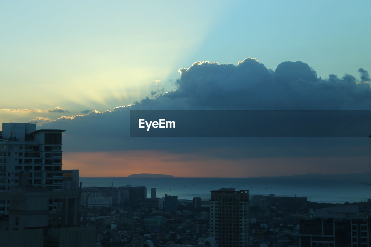 Buildings in city against sky at sunset