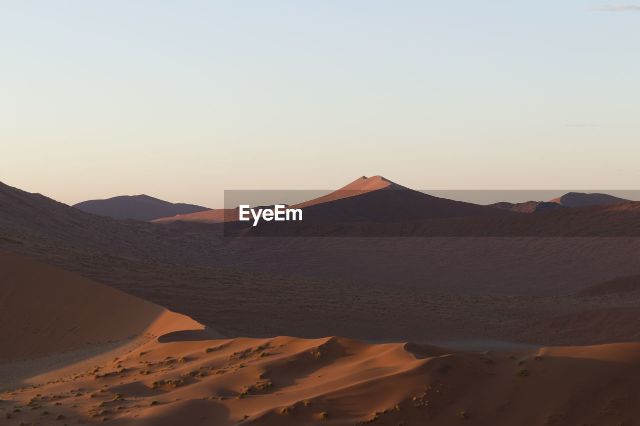 Scenic view of desert against sky during sunset