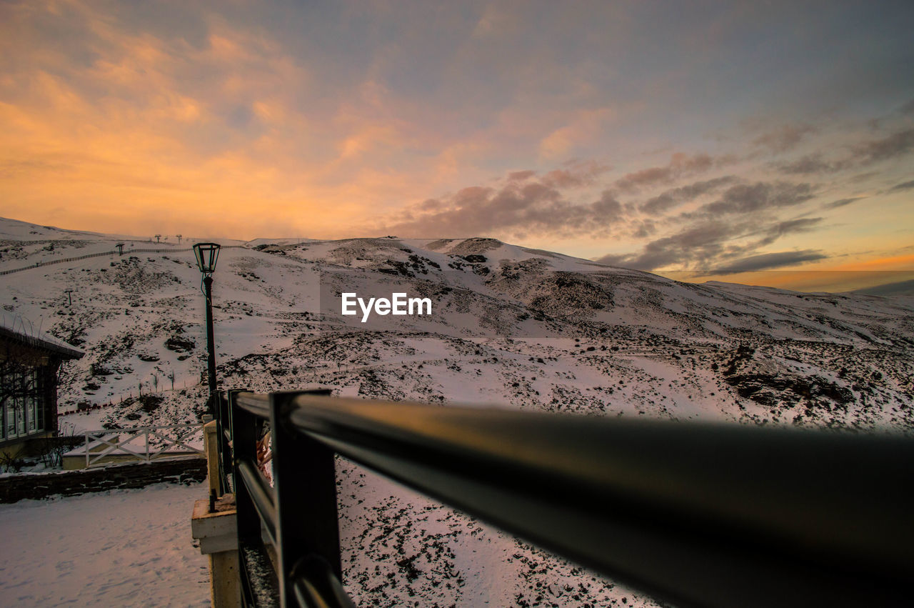 Close-up of snow against sky during sunset